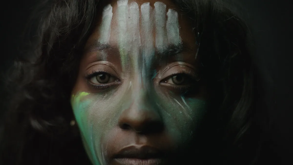 Image of a black woman with paint on her face.